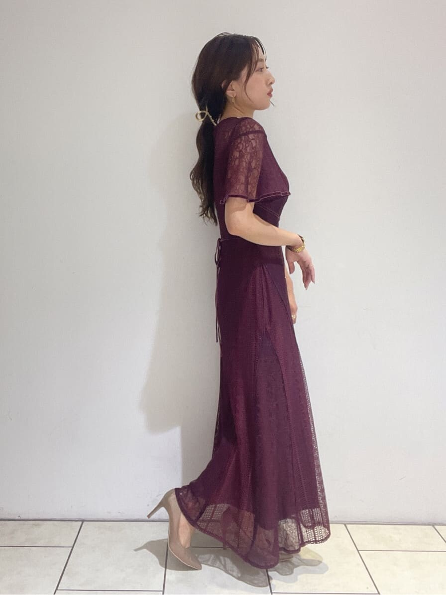 ゴールド系のクラッチバッグ、レッド系のドレス、ゴールド系のパンプスを着用したレディースの夏コーディネートの6枚目の写真