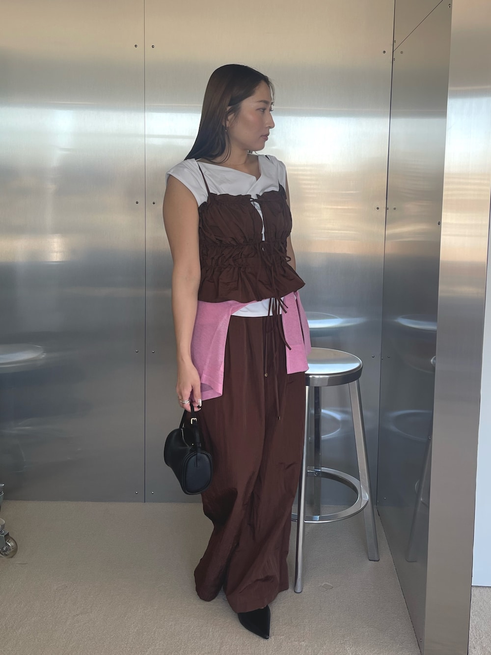 ブラック系のパンプス、ホワイト系のTシャツ/カットソー、ブラウン系のキャミソールを着用したレディースの春コーディネートの4枚目の写真