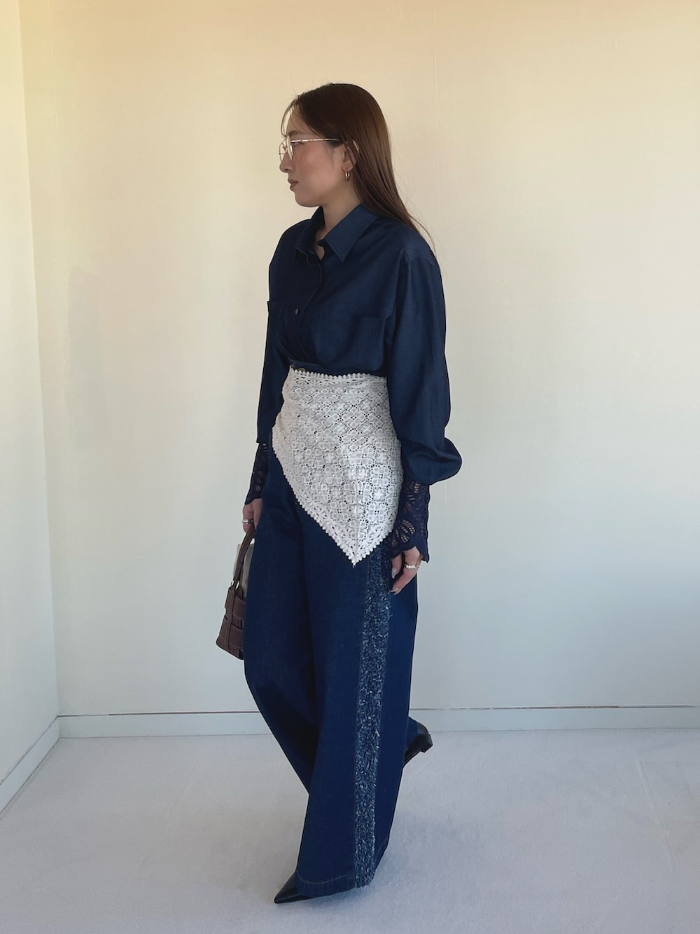 ブラック系のパンプス、ブルー系のデニムパンツ、ブルー系のシャツ/ブラウスを着用したレディースの春コーディネートの6枚目の写真