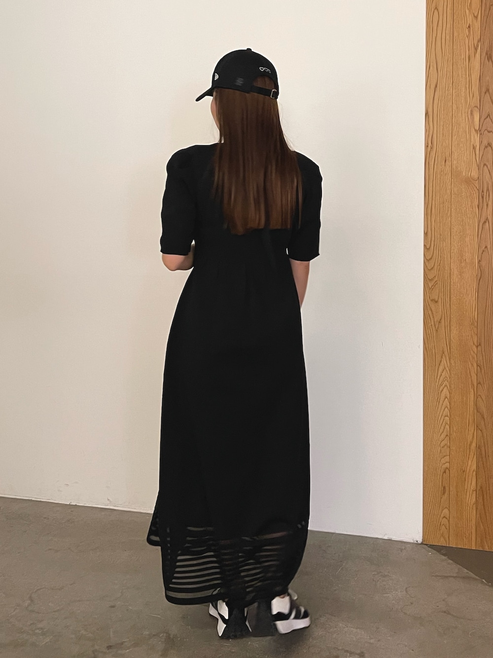 ブラック系のワンピース、ブラック系のキャップを着用したレディースの冬コーディネートの6枚目の写真