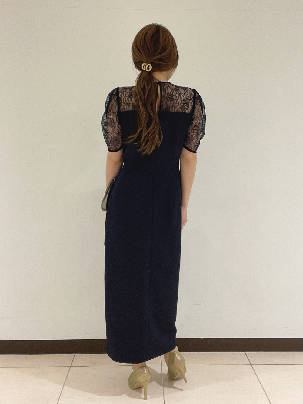 ブルー系のドレス、ゴールド系のハンドバッグ、ゴールド系のパンプスを着用したレディースの夏コーディネートの8枚目の写真