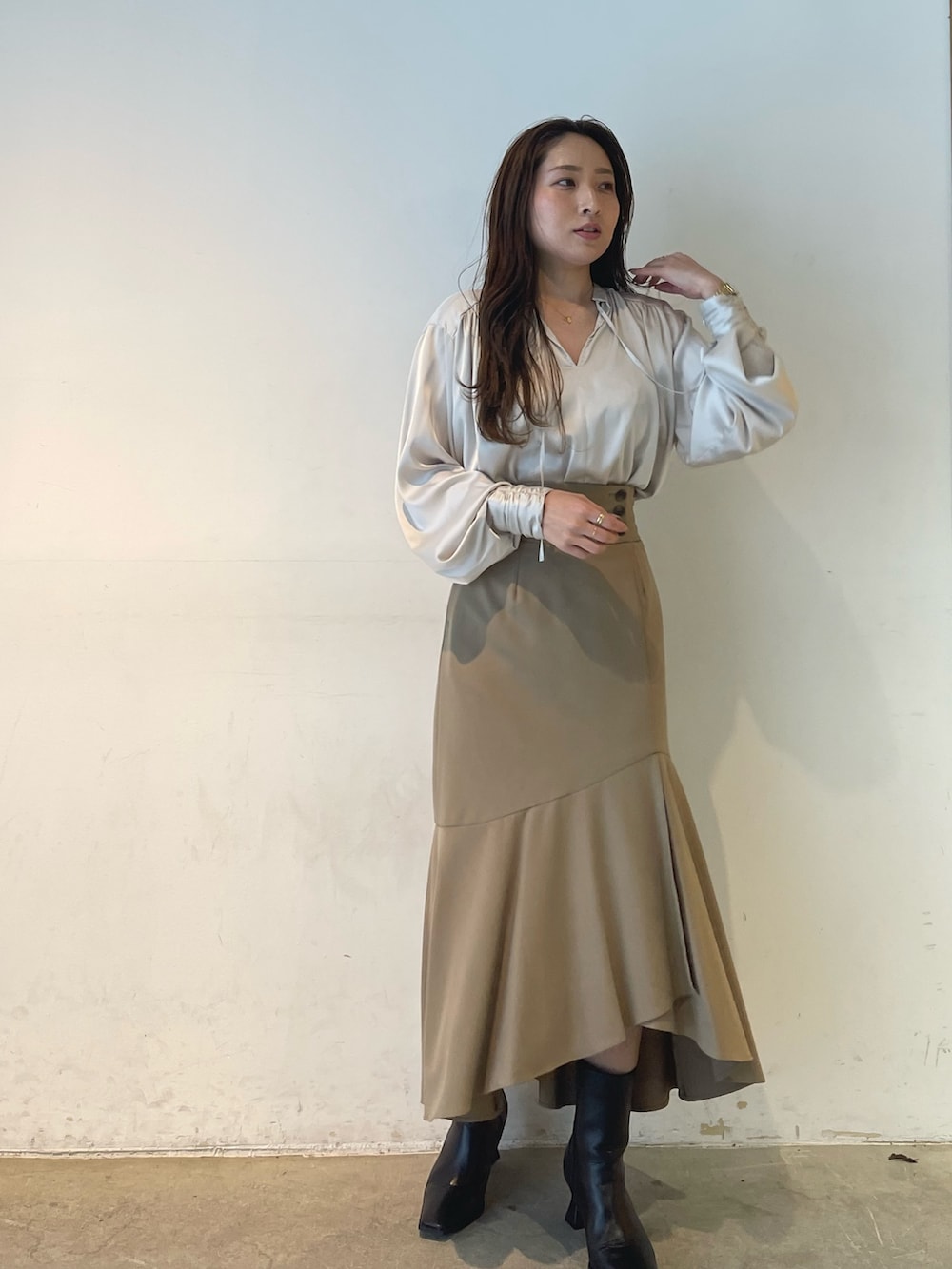 ホワイト系のシャツ/ブラウス、ベージュ系のスカートを着用したレディースの冬コーディネートの2枚目の写真
