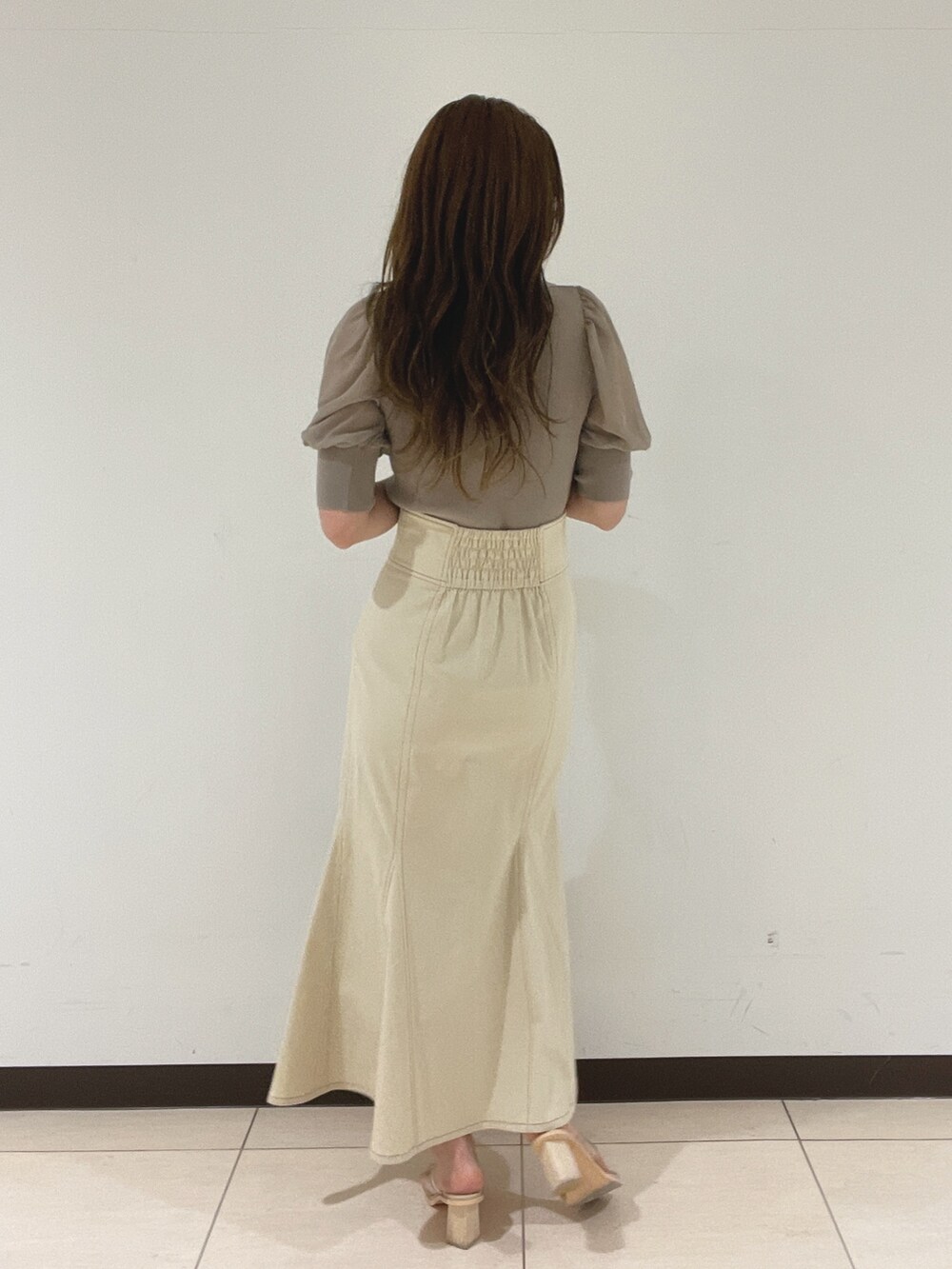 ホワイト系のスカート、その他のサンダル、ブラウン系のニット/セーターを着用したレディースの春コーディネートの6枚目の写真