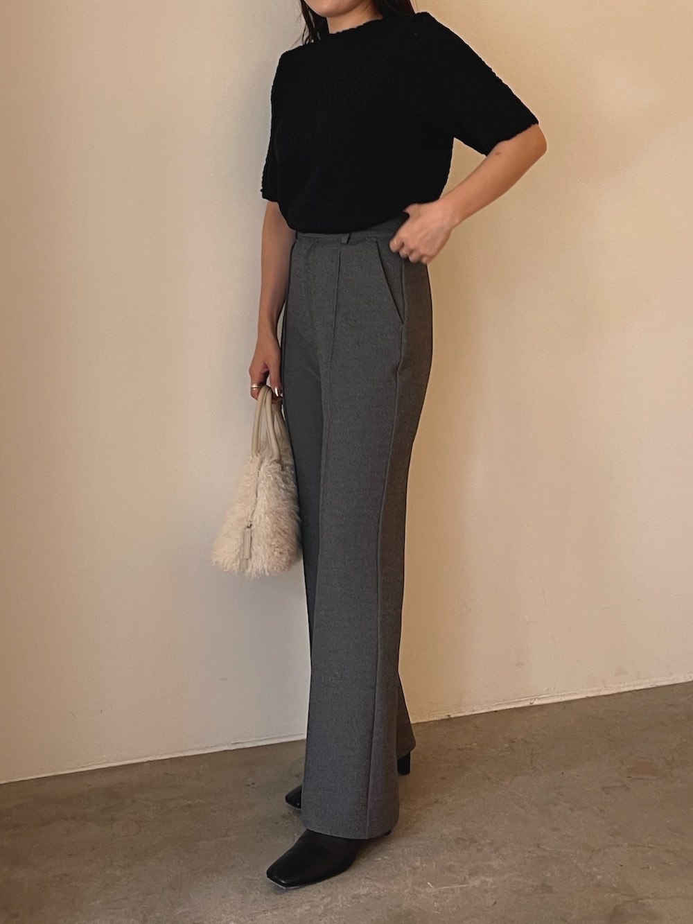 ホワイト系のボストンバッグ、ブラック系のブーツ、ブラック系のニット/セーターを着用したレディースの夏コーディネートの2枚目の写真