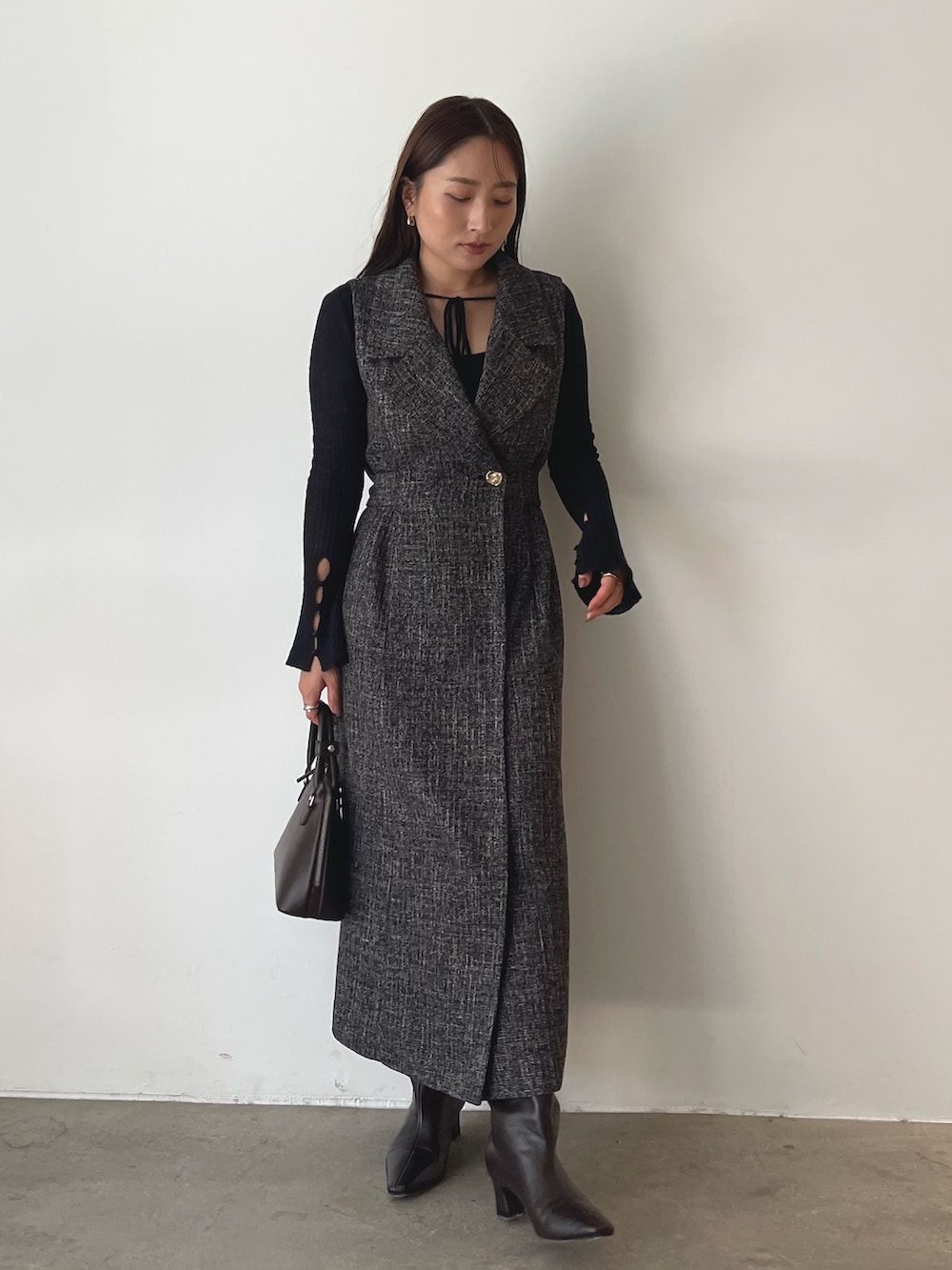 ブラウン系のブーツ、ブラウン系のボストンバッグ、ブラック系のニット/セーターを着用したレディースの秋コーディネートの4枚目の写真