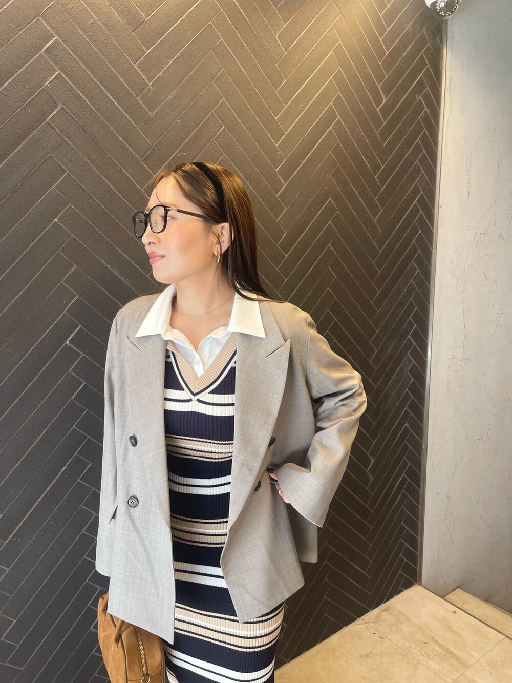 イエロー系のハンドバッグ、ベージュ系のワンピース、グレー系のテーラードジャケットを着用したレディースの冬コーディネートの8枚目の写真