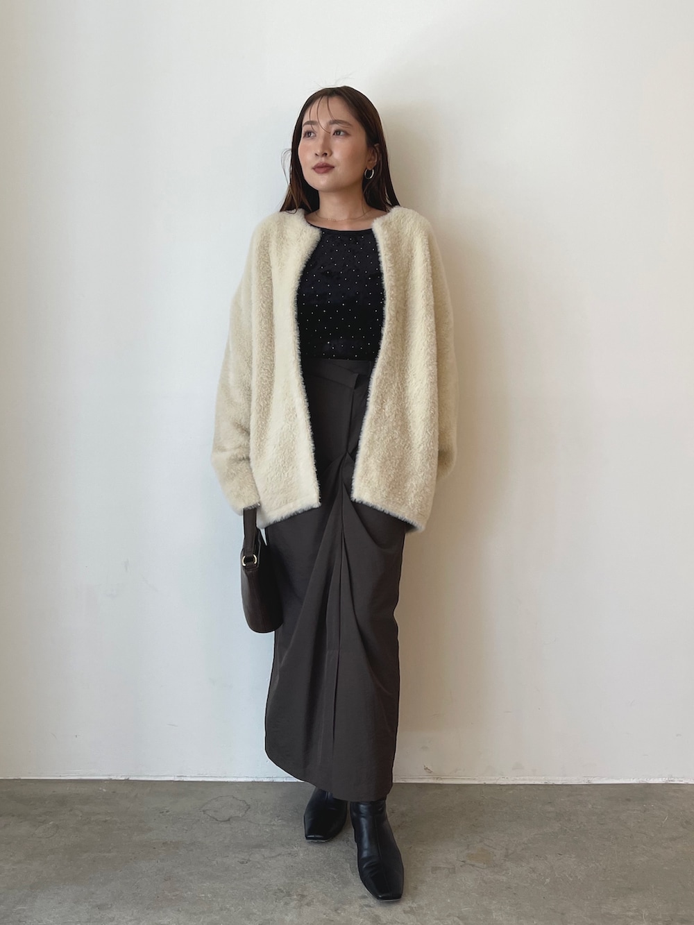 ブラック系のTシャツ/カットソー、ブラウン系のハンドバッグ、ブラウン系のスカートを着用したレディースの秋コーディネートの5枚目の写真