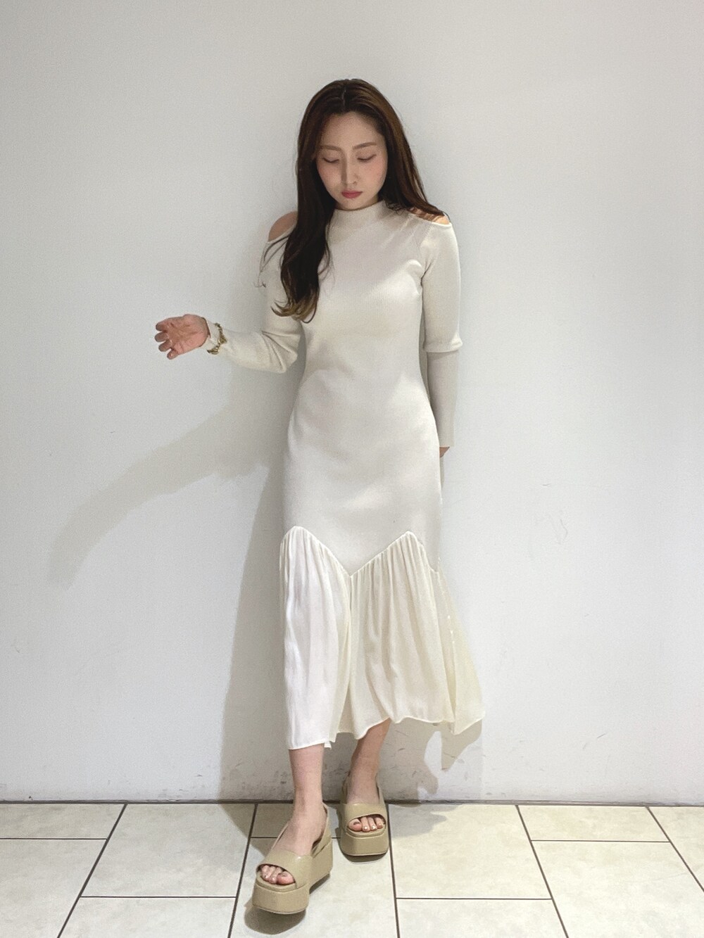 ホワイト系のワンピース、ベージュ系のサンダルを着用したレディースの冬コーディネートの3枚目の写真