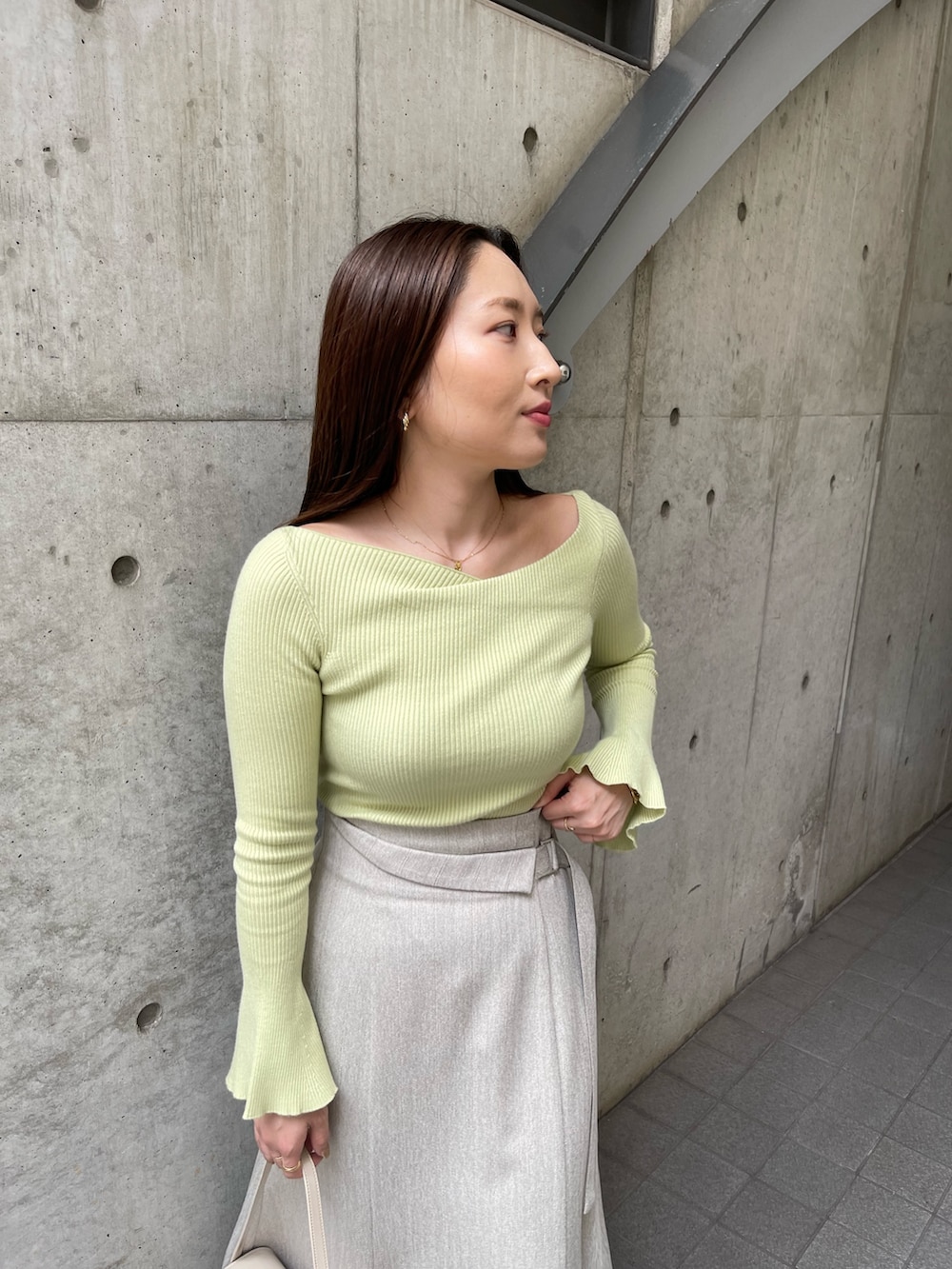 ホワイト系のショルダーバッグ、ホワイト系のパンプス、グレー系のスカートを着用したレディースの秋コーディネートの8枚目の写真