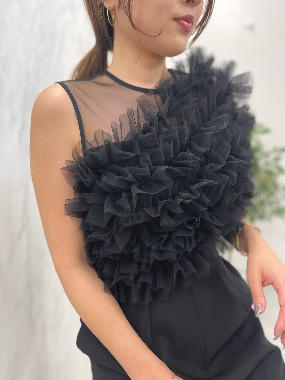 ブラック系のパンツドレス、ゴールド系のパンプスを着用したレディースの冬コーディネートの7枚目の写真