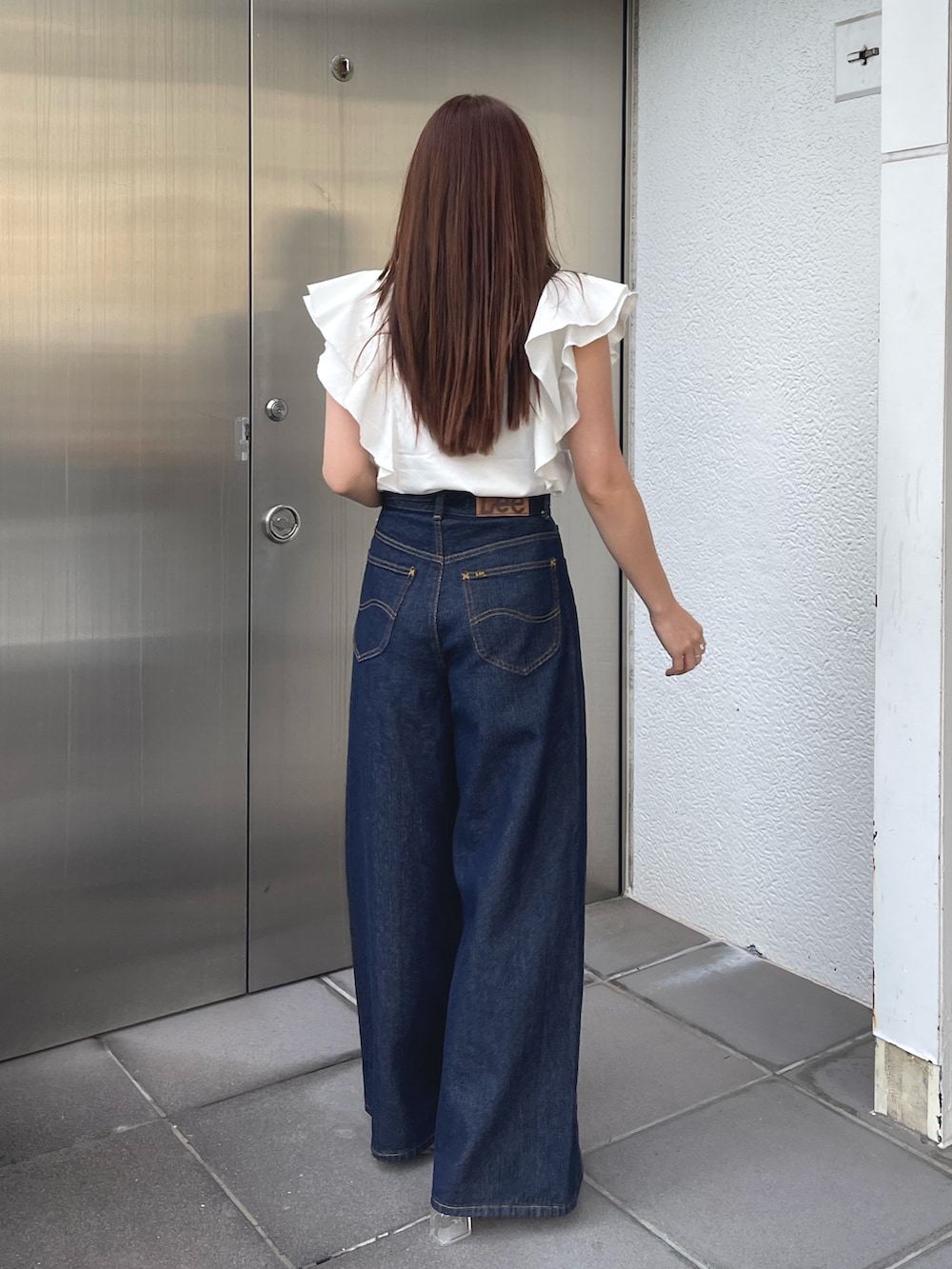 ホワイト系のサンダル、ホワイト系のシャツ/ブラウス、ブルー系のデニムパンツを着用したレディースの春コーディネートの7枚目の写真