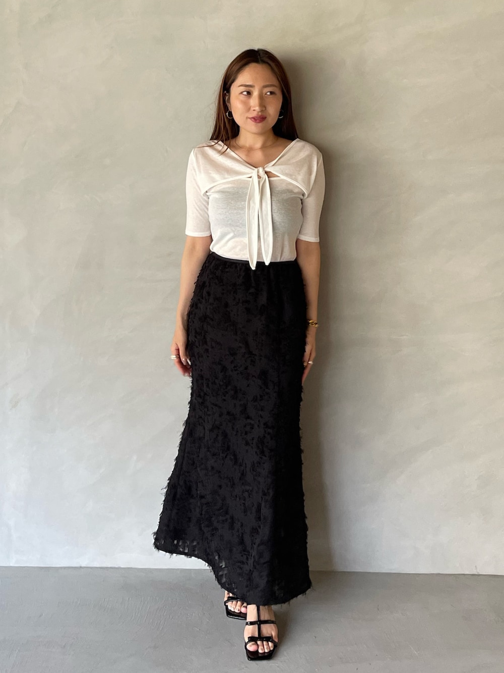 ブラック系のサンダル、ブラック系のスカート、ホワイト系のTシャツ/カットソーを着用したレディースの夏コーディネートの3枚目の写真