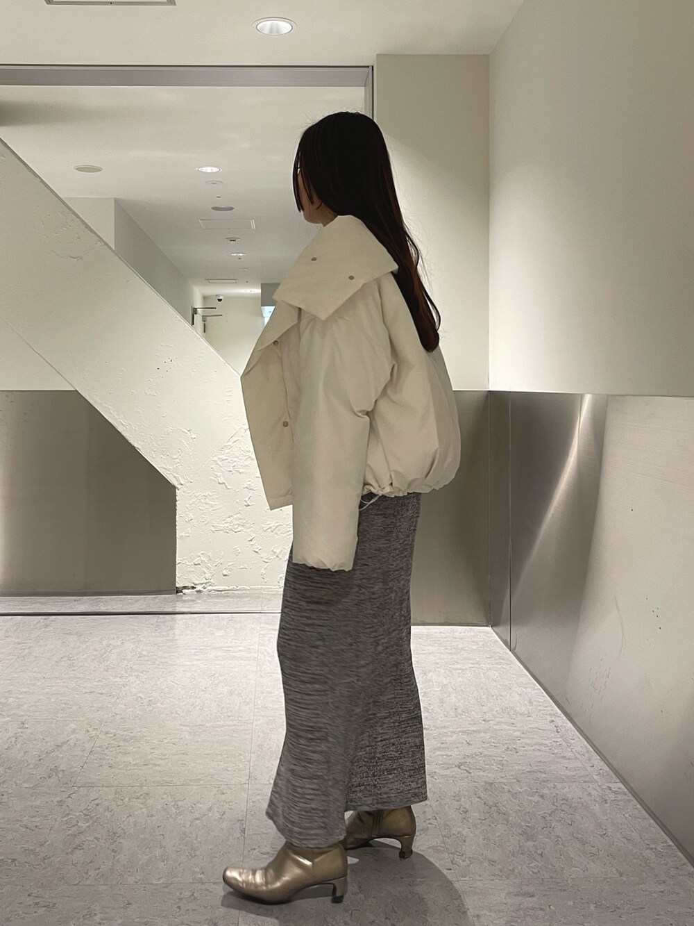 グレー系のワンピース、ホワイト系のダウンジャケット/コートを着用したレディースの冬コーディネートの6枚目の写真