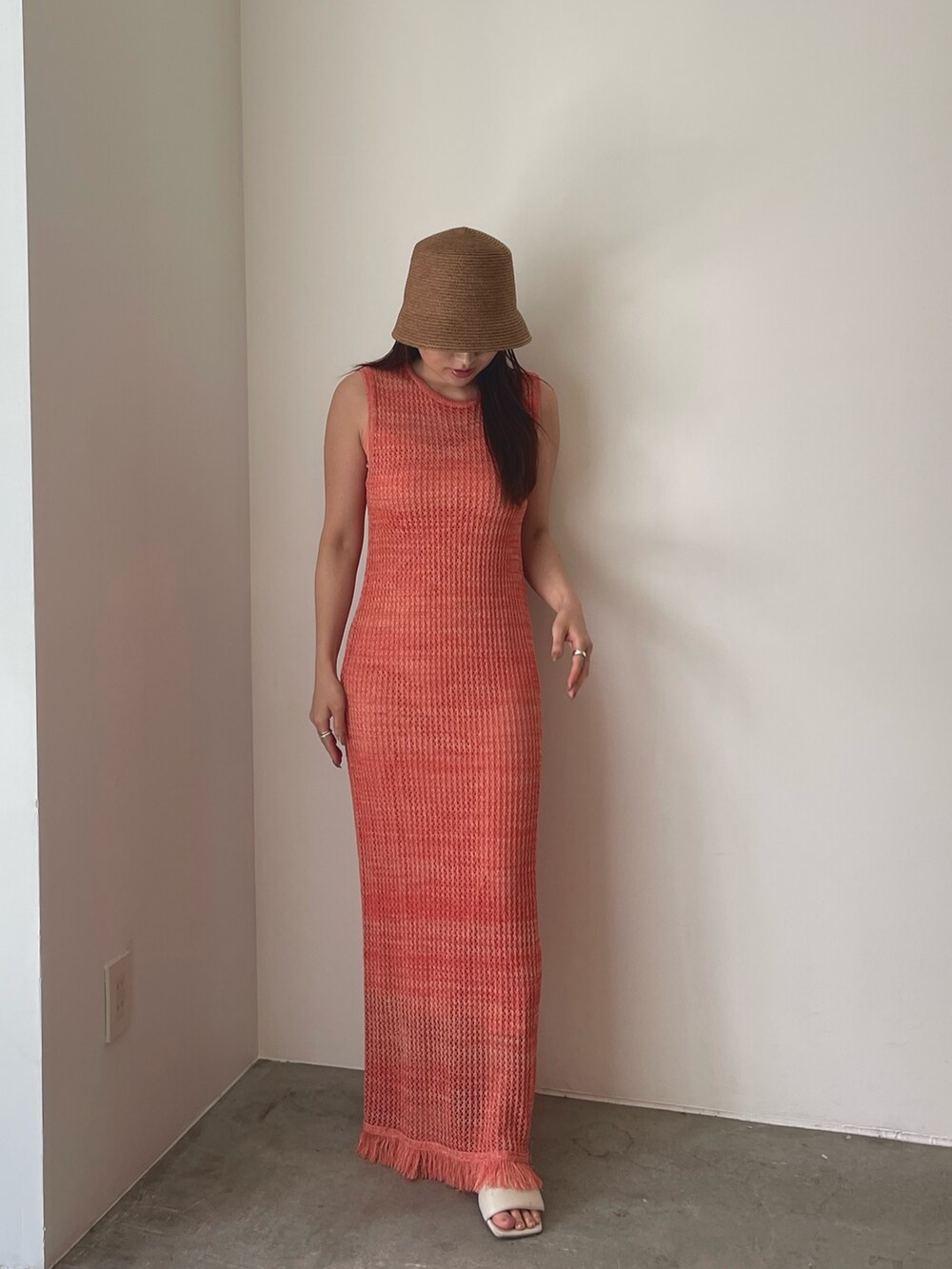 ホワイト系のサンダル、オレンジ系のワンピース、ブラウン系のハットを着用したレディースの春コーディネートの9枚目の写真