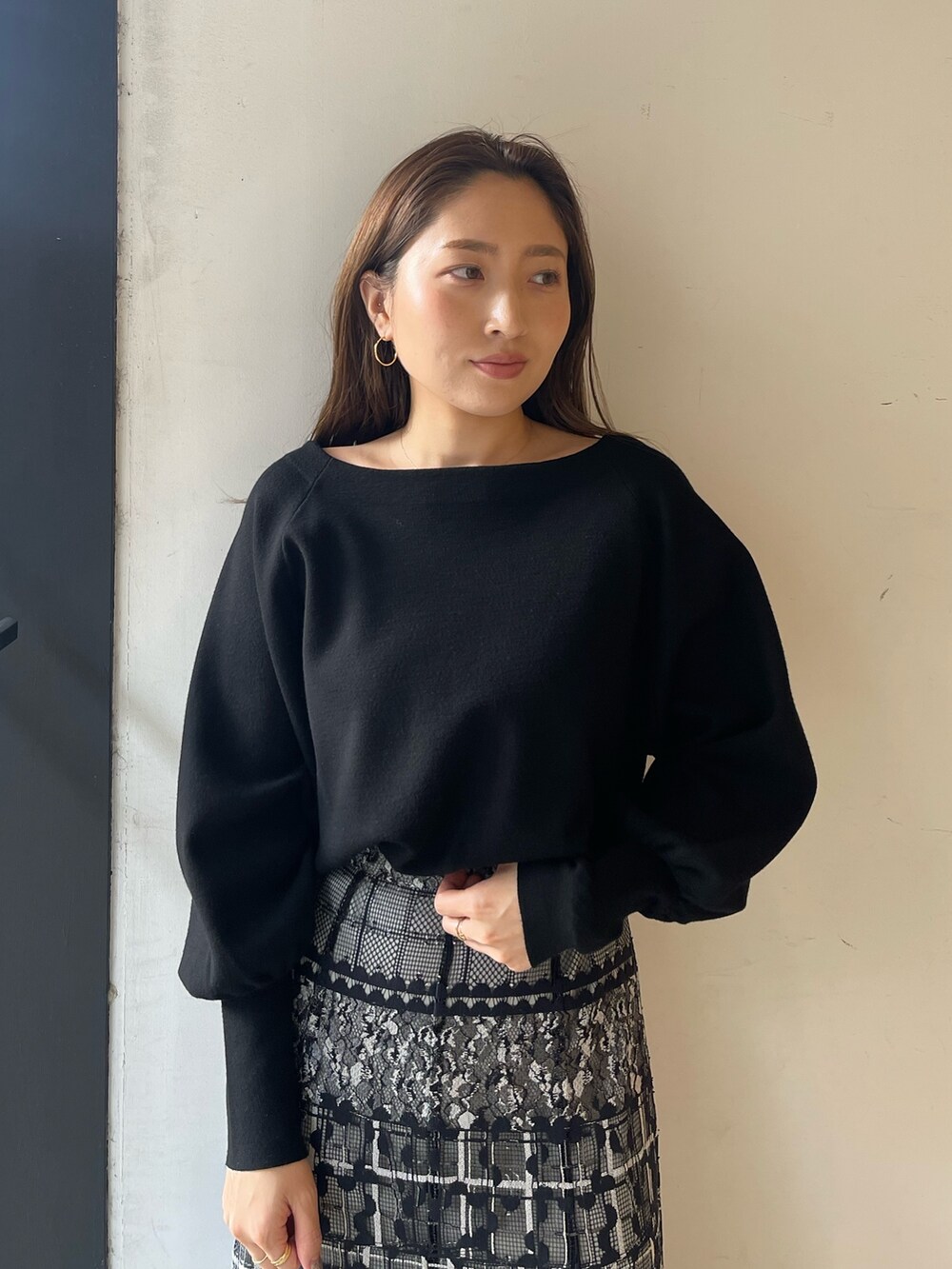 ブラック系のニット/セーター、ホワイト系のブーツ、ブラック系のスカートを着用したレディースの冬コーディネートの7枚目の写真