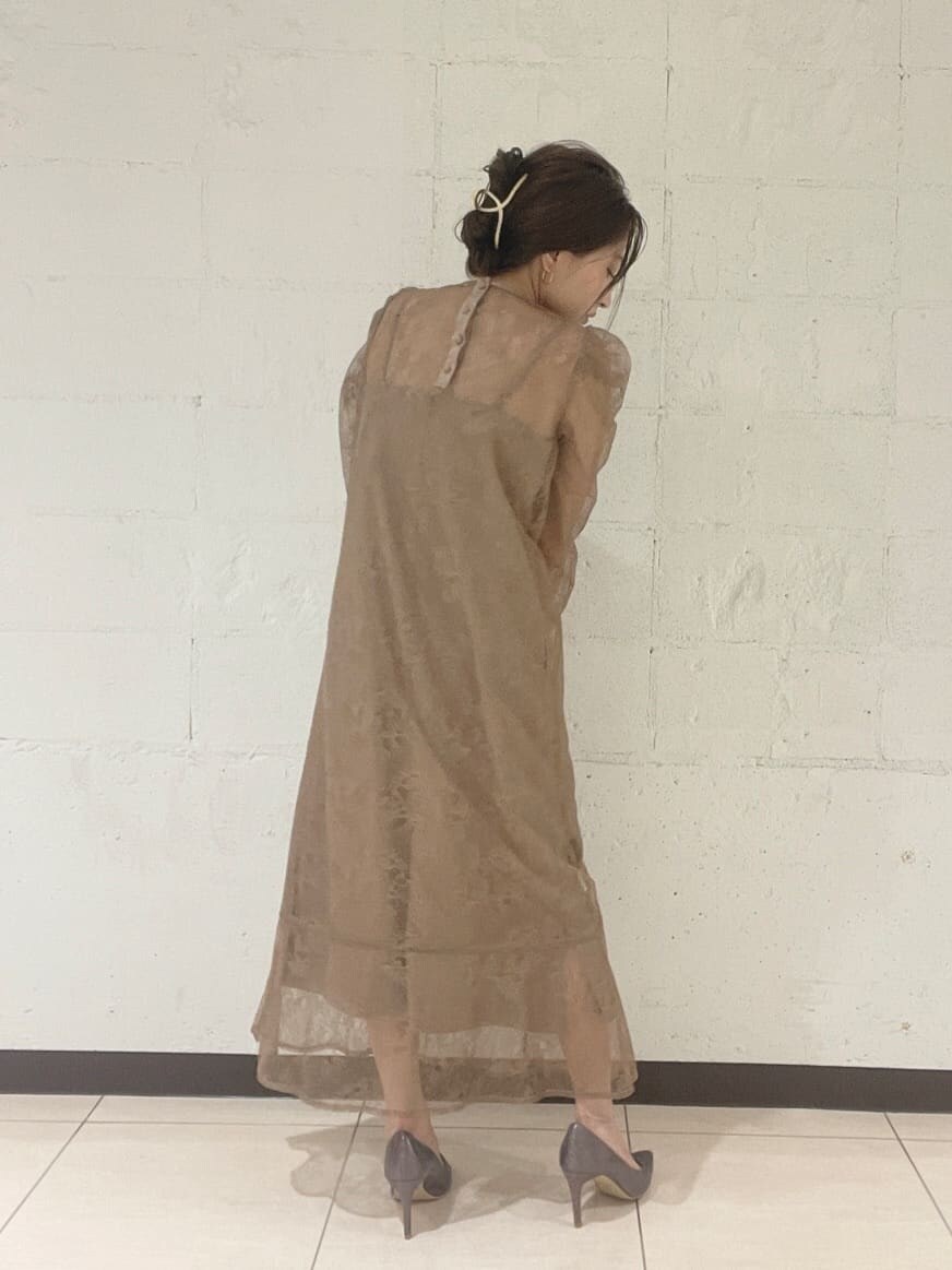 シルバー系のパンプス、シルバー系のハンドバッグ、ベージュ系のドレスを着用したレディースの秋コーディネートの4枚目の写真