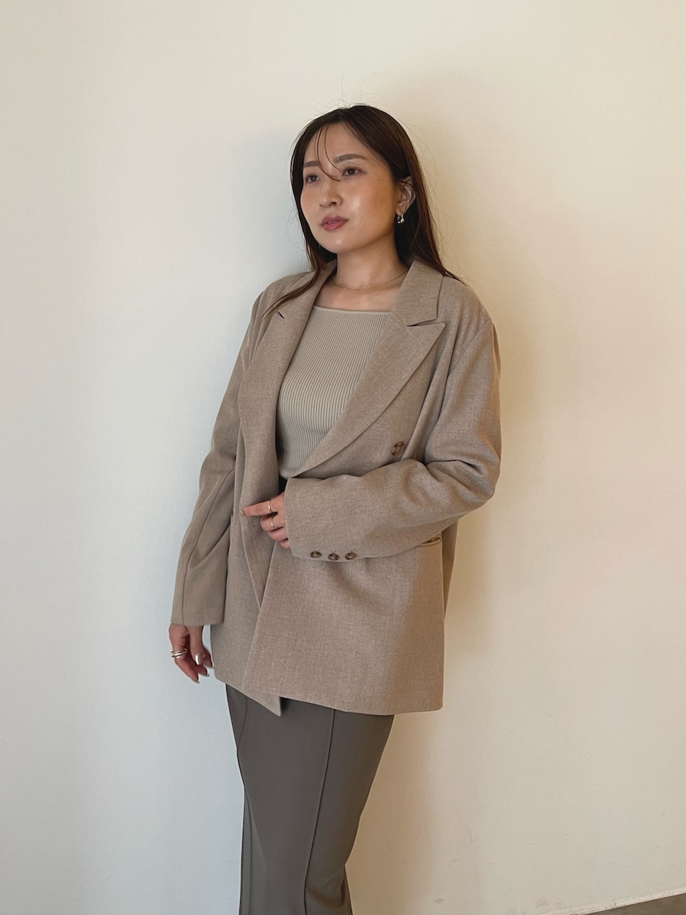 ブラック系のパンプス、グレー系のスカート、ベージュ系のニット/セーターを着用したレディースの秋コーディネートの6枚目の写真