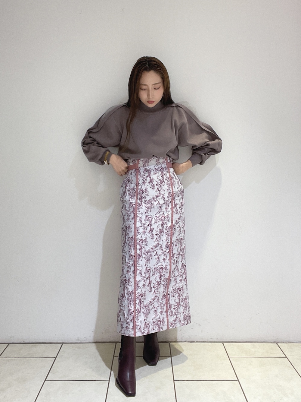 ピンク系のスカート、ブラウン系のニット/セーター、レッド系のブーツを着用したレディースの冬コーディネートの5枚目の写真