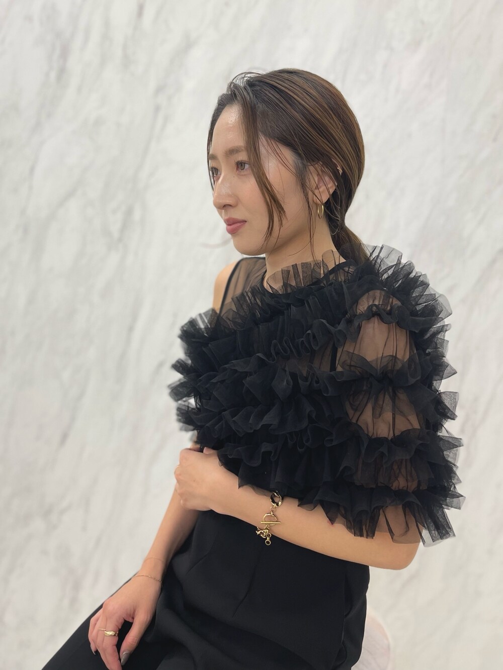 ブラック系のパンツドレス、ゴールド系のパンプスを着用したレディースの冬コーディネートの6枚目の写真