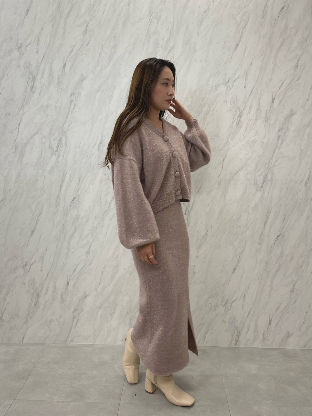 ピンク系のカーディガン/ボレロ、ピンク系のスカート、ホワイト系のブーツを着用したレディースの冬コーディネートの4枚目の写真