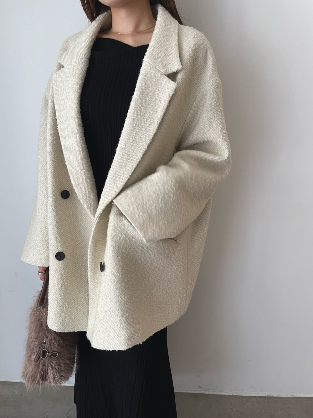 ブラック系のワンピース、ベージュ系のパンプス、ブラウン系のボストンバッグを着用したレディースの秋コーディネートの7枚目の写真