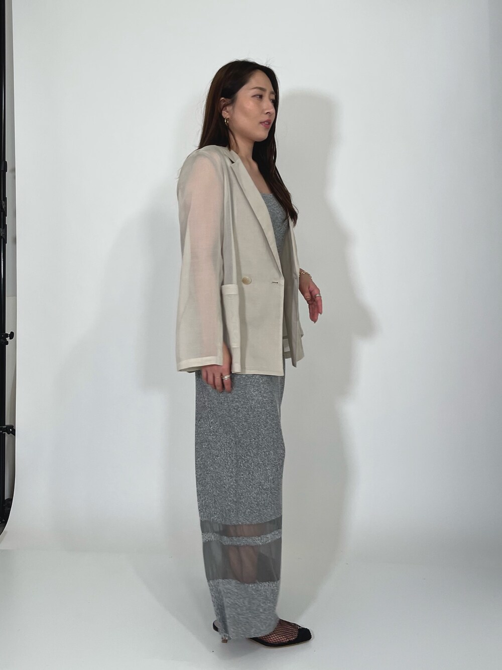 ホワイト系のテーラードジャケット、グレー系のワンピース、ブラック系のサンダルを着用したレディースの夏コーディネートの4枚目の写真