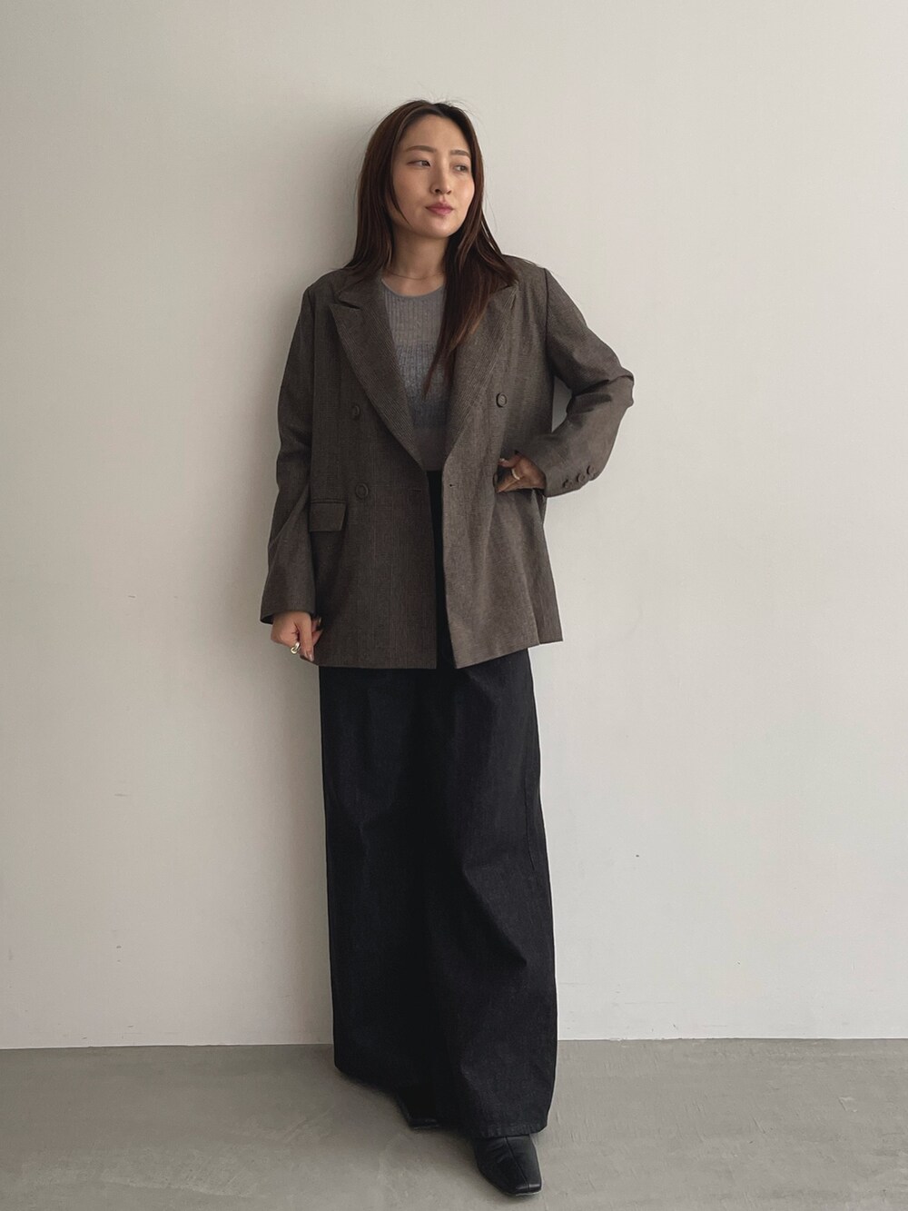 ブラック系のデニムパンツ、グレー系のニット/セーター、ブラウン系のテーラードジャケットを着用したレディースの夏コーディネートの3枚目の写真