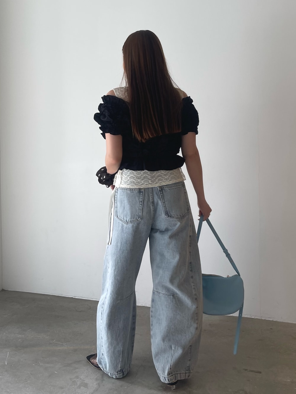 ブラック系のパンツドレス、ブルー系のデニムパンツ、ホワイト系のシャツ/ブラウスを着用したレディースの春コーディネートの6枚目の写真