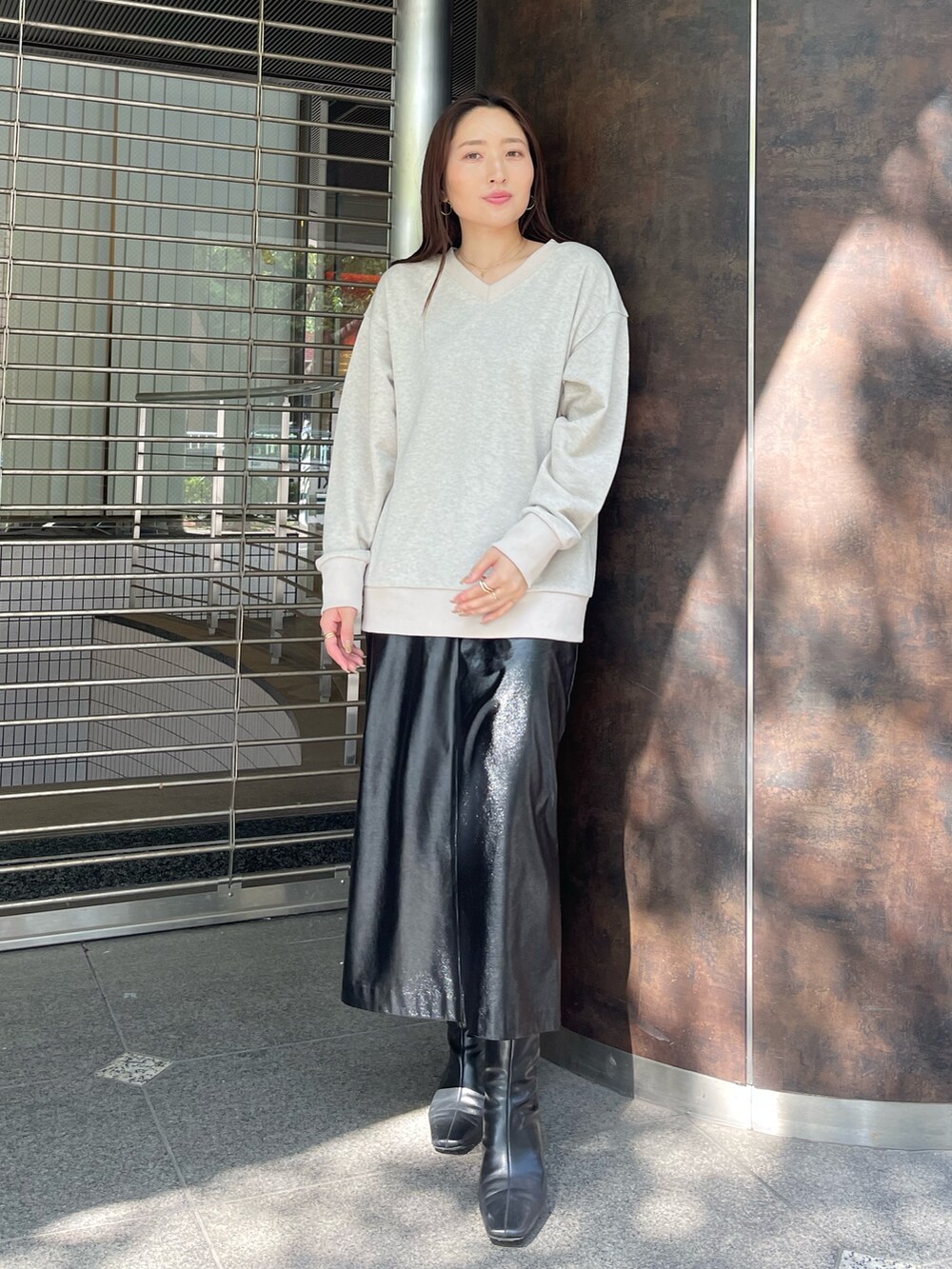 ブラック系のブーツ、ブラック系のスカート、ベージュ系のスウェットを着用したレディースの夏コーディネートの3枚目の写真