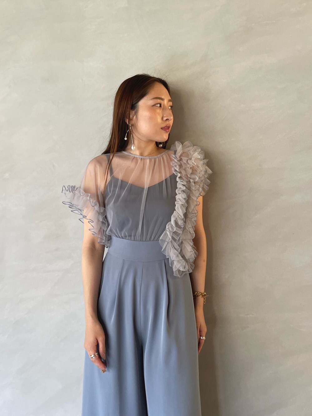 ブルー系のパンツドレス、ゴールド系のピアス（両耳用）を着用したレディースの夏コーディネートの8枚目の写真