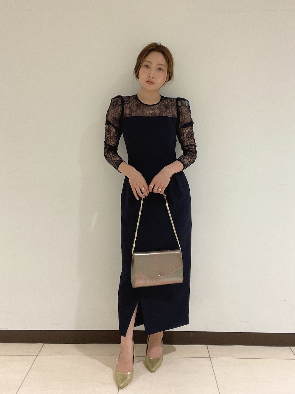 ゴールド系のハンドバッグ、ゴールド系のパンプス、ブルー系のドレスを着用したレディースの夏コーディネートの2枚目の写真