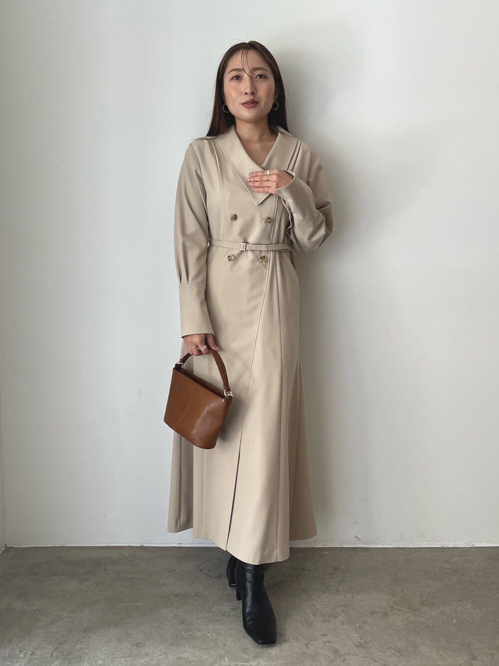 ブラック系のブーツ、ベージュ系のワンピース、イエロー系のハンドバッグを着用したレディースの秋コーディネートの4枚目の写真