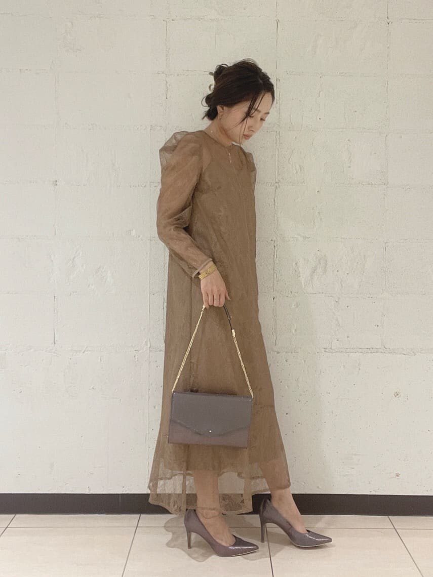 シルバー系のパンプス、シルバー系のハンドバッグ、ベージュ系のドレスを着用したレディースの秋コーディネートの9枚目の写真