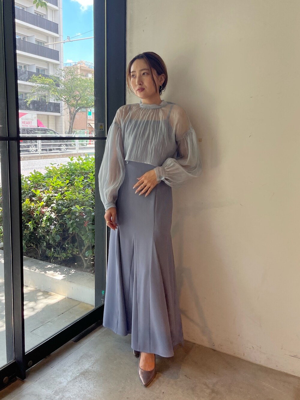 シルバー系のパンプス、ブルー系のドレスを着用したレディースの秋コーディネートの2枚目の写真