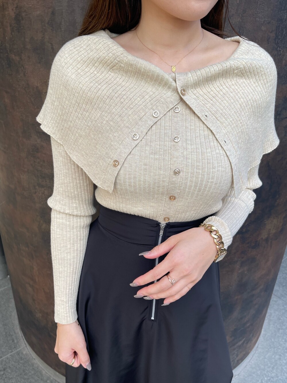 ホワイト系のブーツ、ベージュ系のニット/セーター、ブラック系のスカートを着用したレディースの冬コーディネートの6枚目の写真