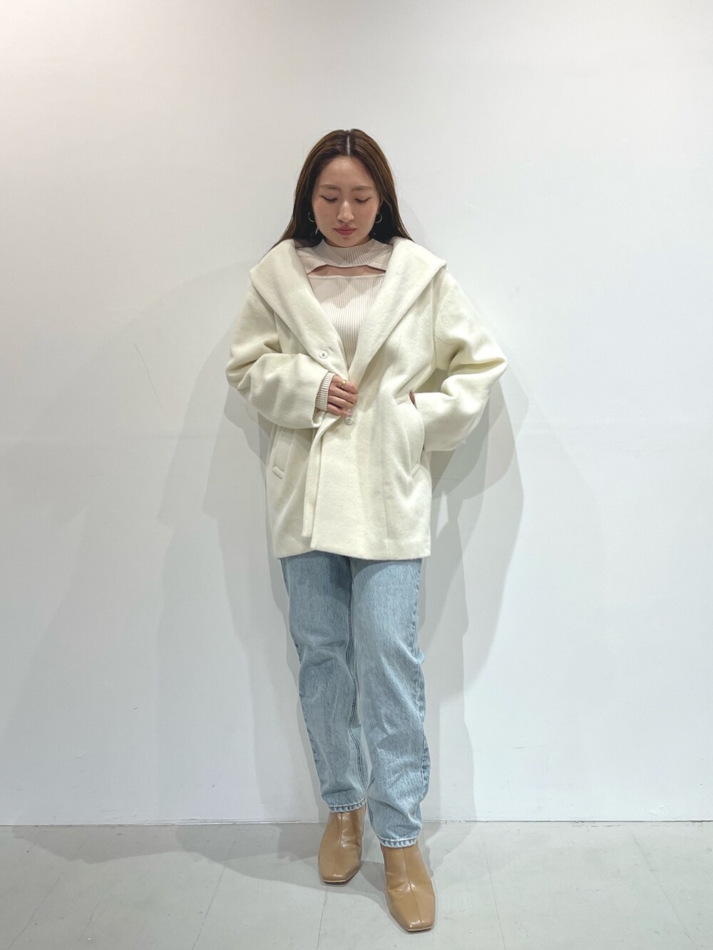 ホワイト系のニット/セーター、ベージュ系のブーツ、ホワイト系のその他アウターを着用したレディースの秋コーディネートの5枚目の写真