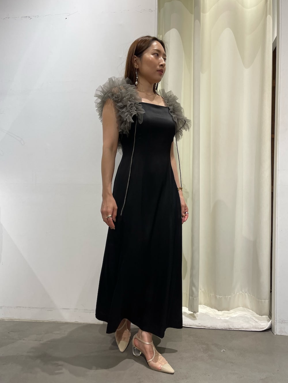 ブラック系のドレス、ゴールド系のピアス(両耳用)を着用したレディースの夏コーディネートの5枚目の写真