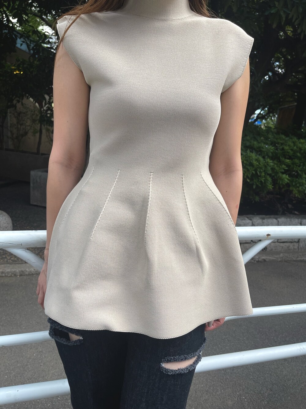 ベージュ系のニット/セーター、ブラック系のブーツ、ブラック系のデニムパンツを着用したレディースの秋コーディネートの5枚目の写真