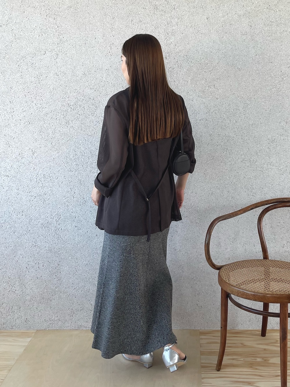 シルバー系のパンプス、ブラック系のワンピース、ブラウン系のテーラードジャケットを着用したレディースの春コーディネートの5枚目の写真