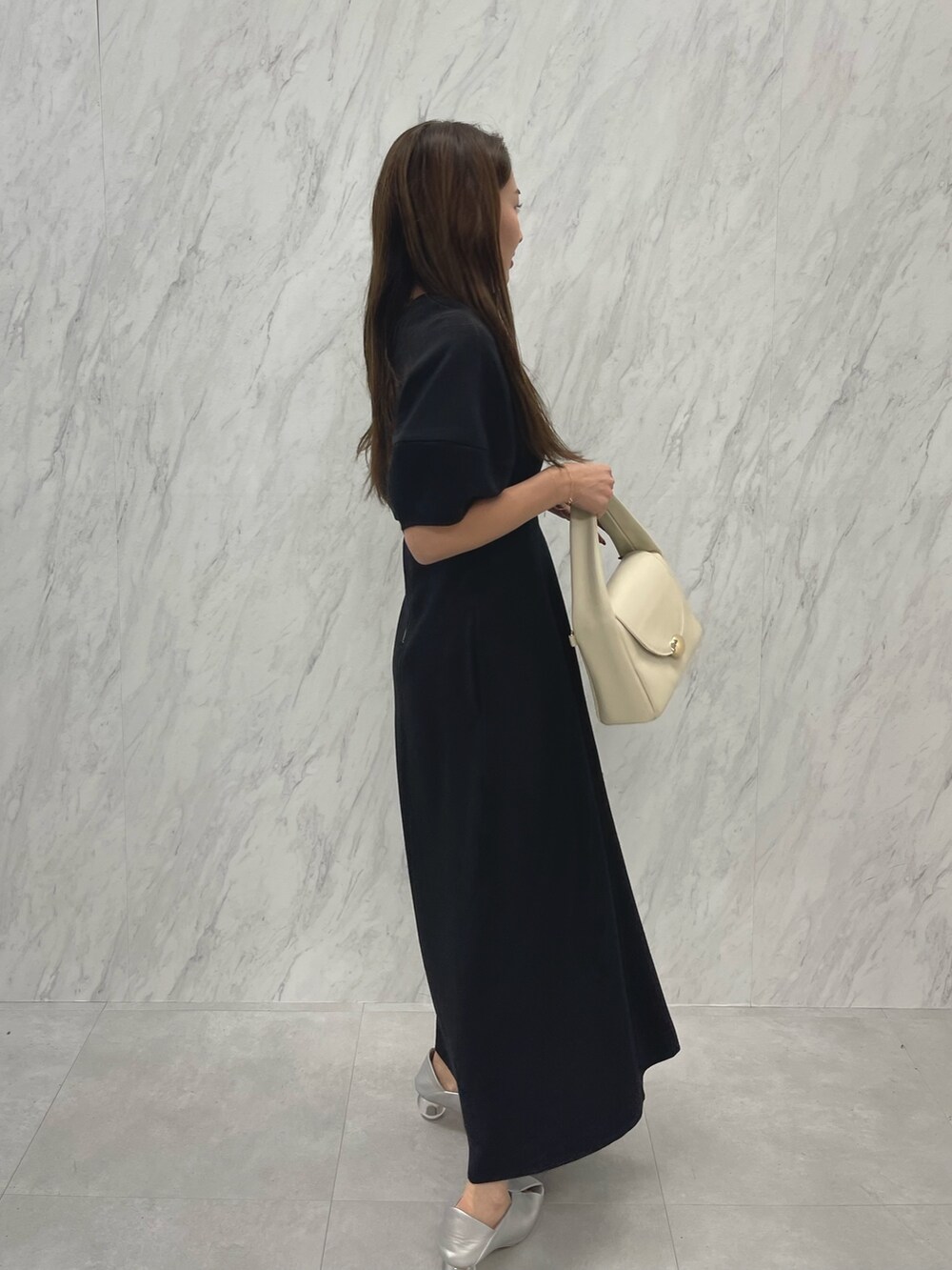 シルバー系のパンプス、ホワイト系のハンドバッグ、ブラック系のパンプスを着用したレディースの冬コーディネートの6枚目の写真