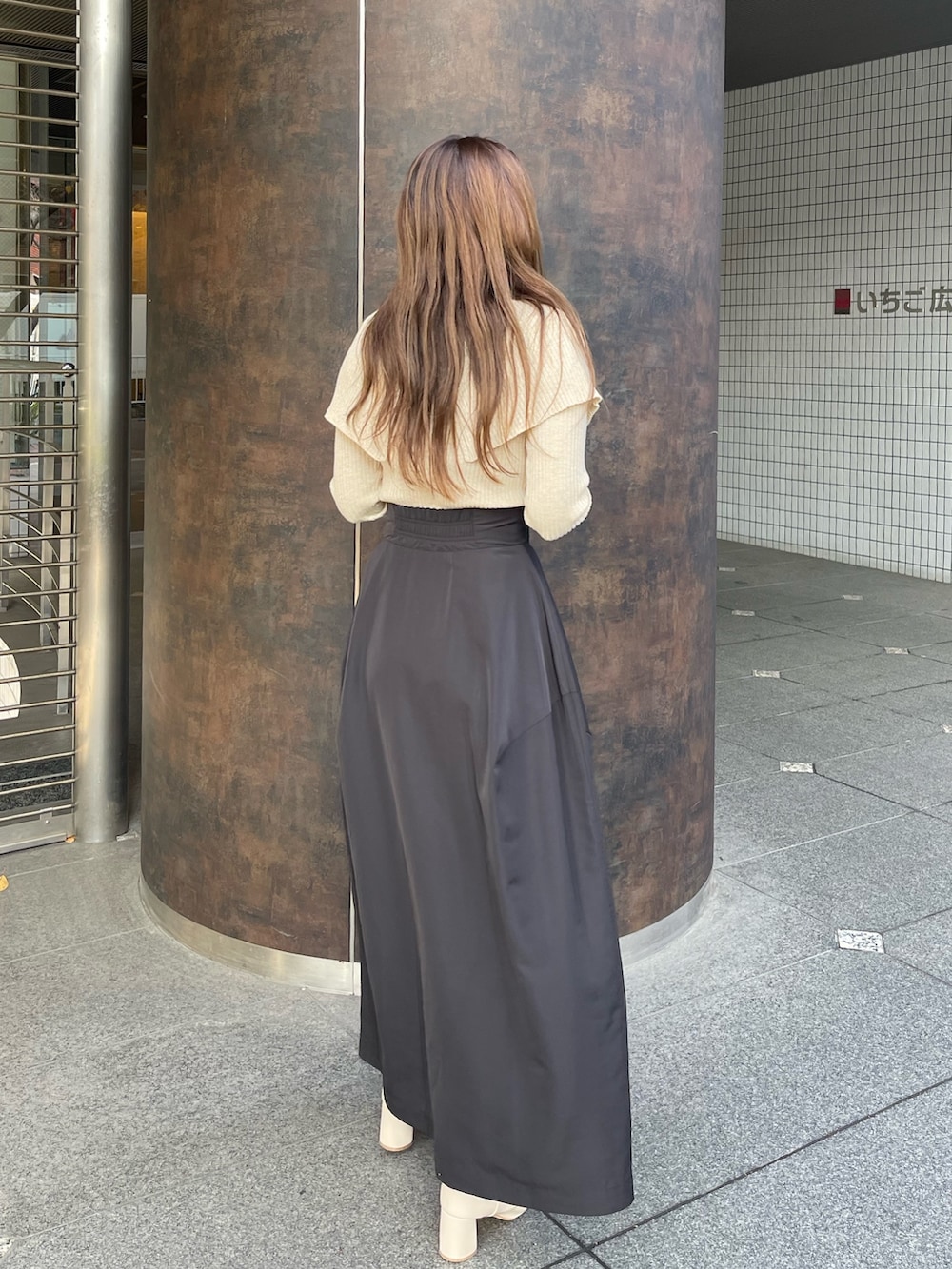 ホワイト系のブーツ、ベージュ系のニット/セーター、ブラック系のスカートを着用したレディースの冬コーディネートの3枚目の写真