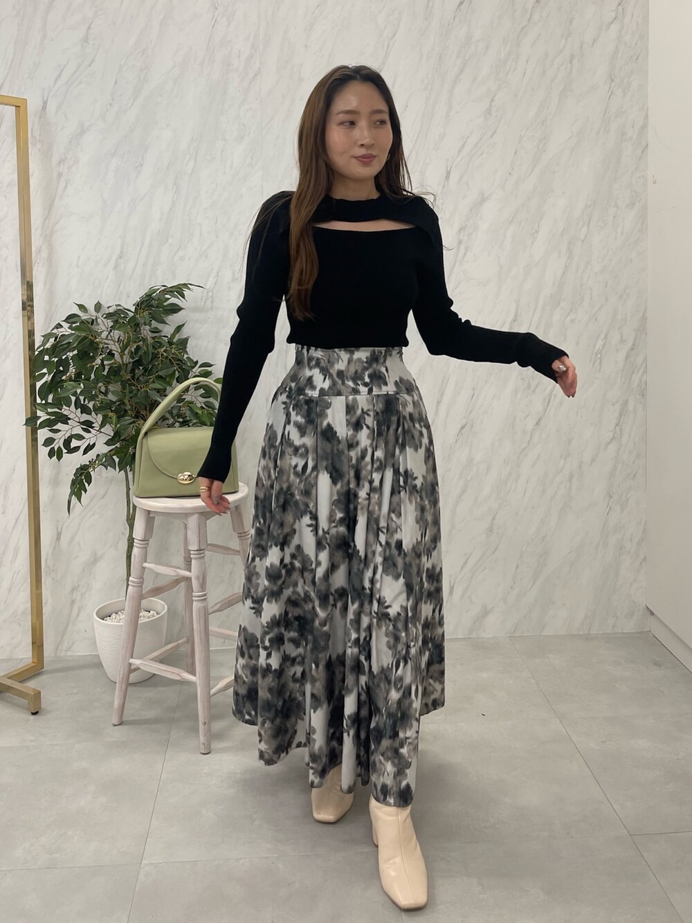 ホワイト系のブーツ、ブラック系のニット/セーター、グリーン系のハンドバッグを着用したレディースの冬コーディネートの5枚目の写真