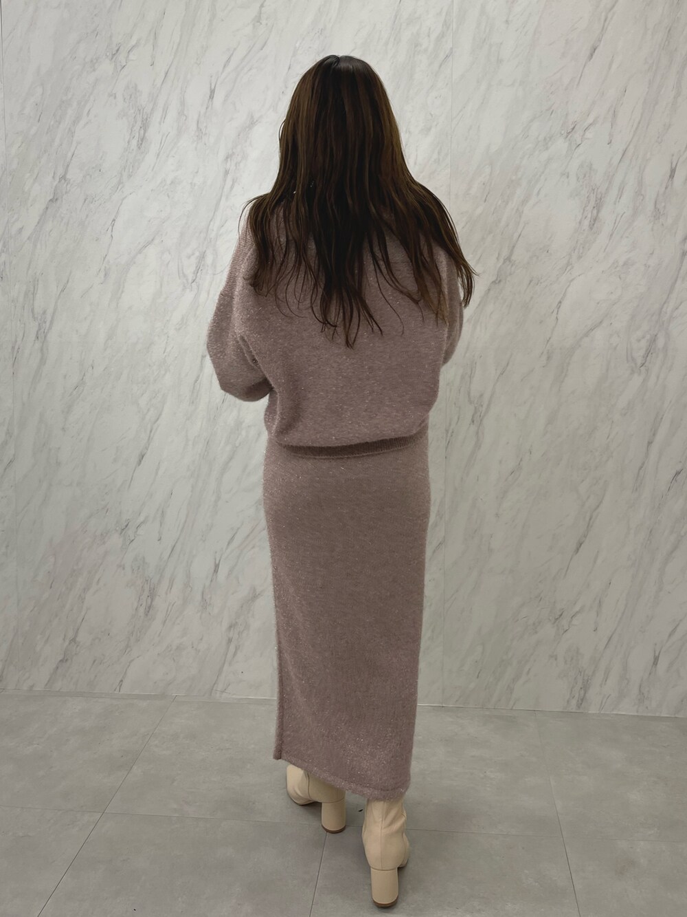 ピンク系のカーディガン/ボレロ、ピンク系のスカート、ホワイト系のブーツを着用したレディースの冬コーディネートの6枚目の写真