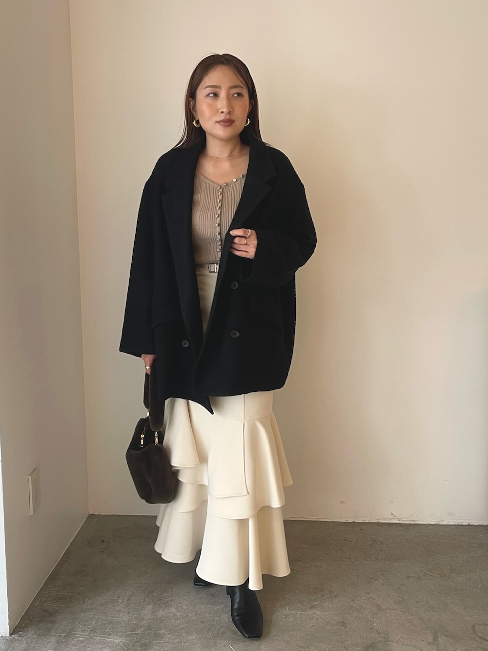 ベージュ系のワンピース、ブラック系のブーツ、ブラウン系のショルダーバッグを着用したレディースの冬コーディネートの2枚目の写真