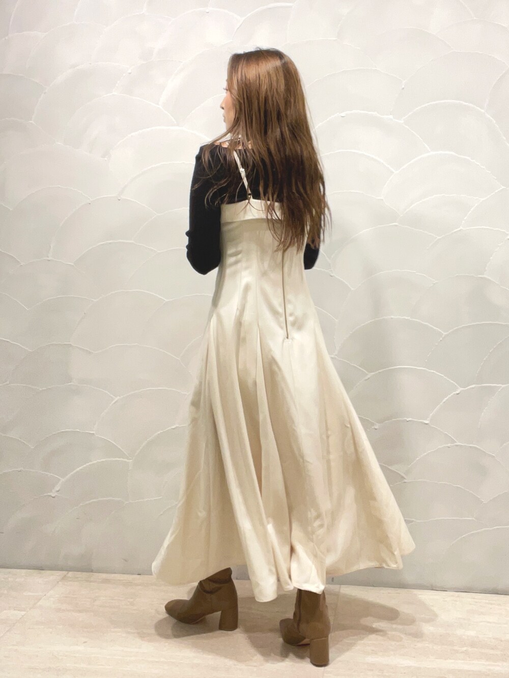 ベージュ系のブーツ、ブラック系のニット/セーター、ホワイト系のワンピースを着用したレディースの秋コーディネートの6枚目の写真