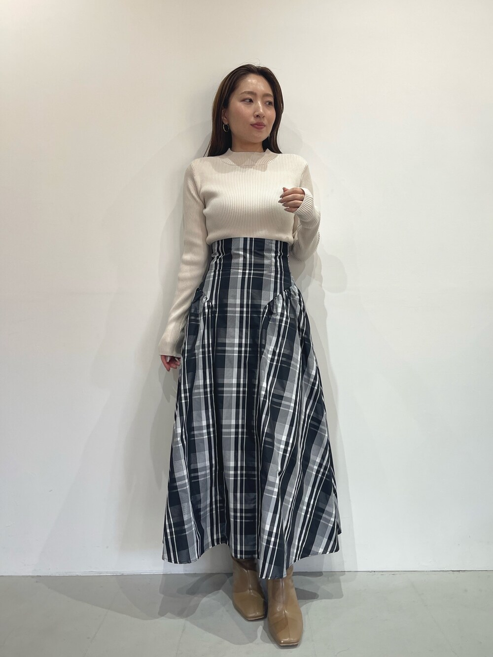 ベージュ系のブーツ、ホワイト系のニット/セーター、ホワイト系のスカートを着用したレディースの秋コーディネートの8枚目の写真