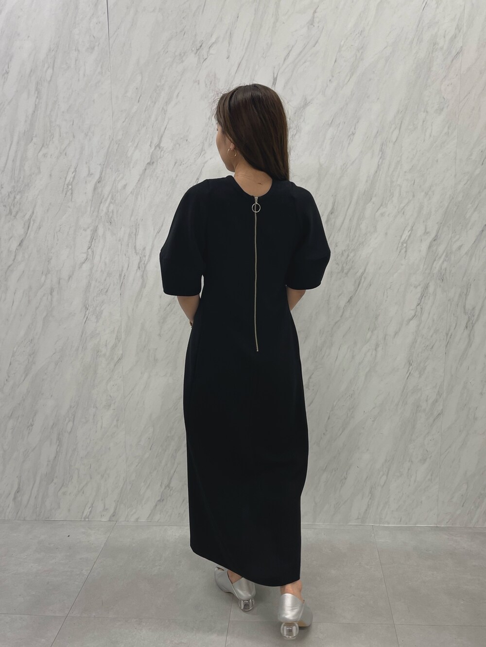 シルバー系のパンプス、ホワイト系のハンドバッグ、ブラック系のパンプスを着用したレディースの冬コーディネートの7枚目の写真