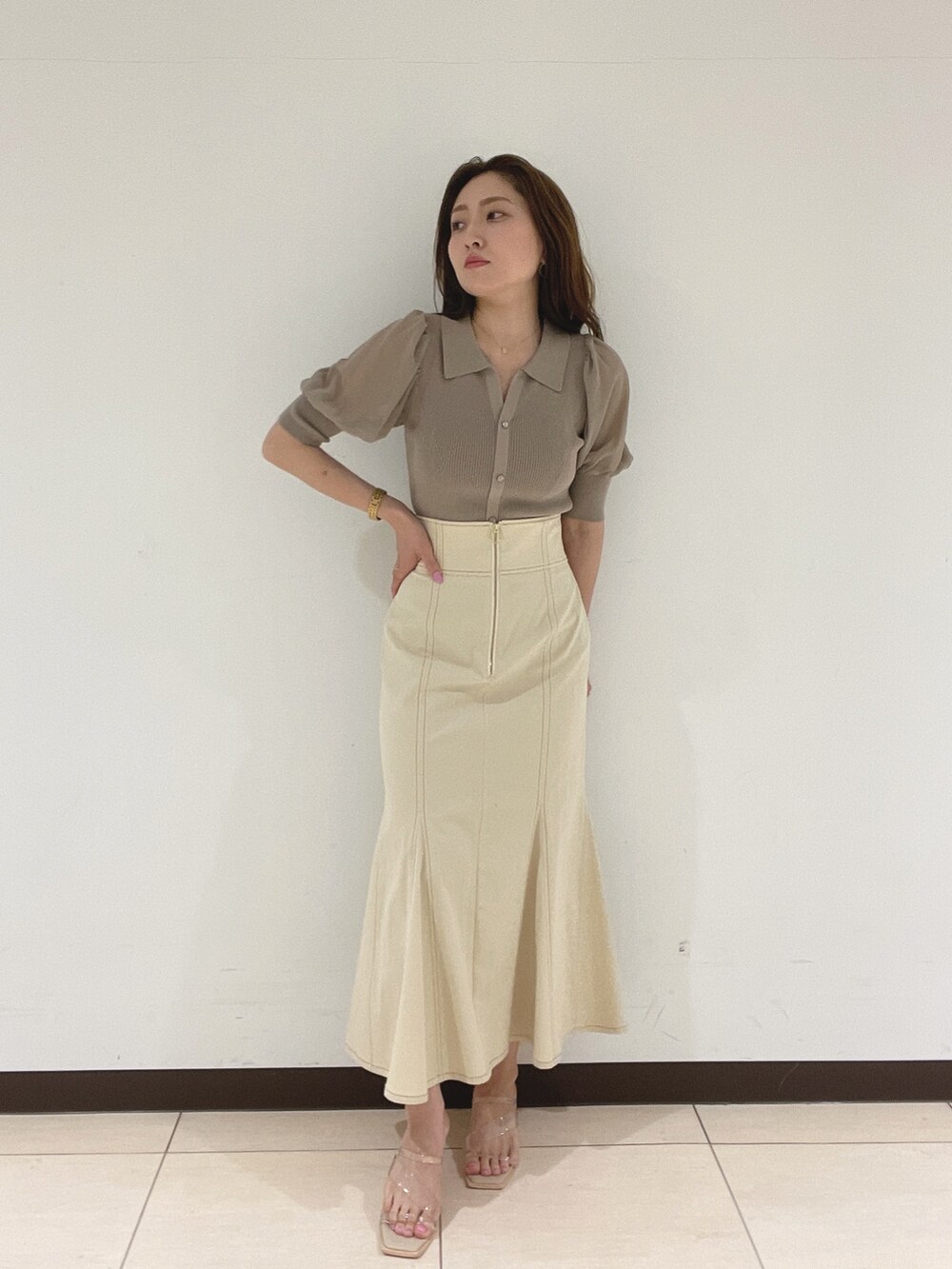 ホワイト系のスカート、その他のサンダル、ブラウン系のニット/セーターを着用したレディースの春コーディネートの3枚目の写真