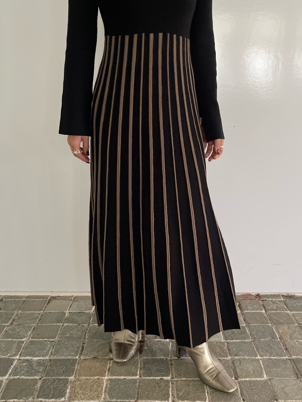 ブラック系のワンピース、シルバー系のブーツを着用したレディースの冬コーディネートの6枚目の写真