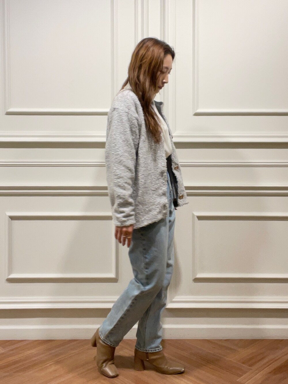 ベージュ系のブーツ、グレー系のカーディガン/ボレロ、ブルー系のデニムパンツを着用したレディースの秋コーディネートの3枚目の写真